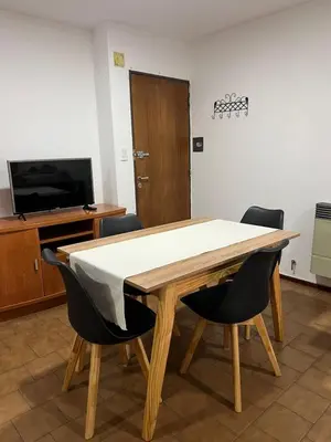 a dining room table with chairs and a television at Estrada 59 Nueva Cordoba in Cordoba