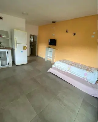 a room with a bed and a refrigerator in it at Casitas Rabe in Santa Rosa de Calamuchita