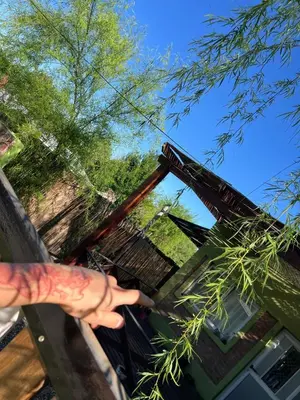 a hand with a tattoo pointing at a building at Casitas Rabe in Santa Rosa de Calamuchita