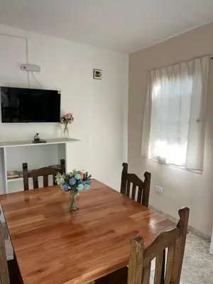 a dining room table with a vase of flowers on it at Casitas Rabe in Santa Rosa de Calamuchita