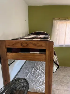 a wooden bunk bed in a room with a window at Casitas Rabe in Santa Rosa de Calamuchita