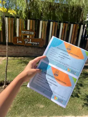 a person holding up a piece of paper at Casitas Rabe in Santa Rosa de Calamuchita