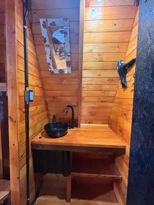a bathroom with a sink in a wooden wall at A Mi Manera Apart in Merlo