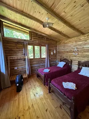 a bedroom with two beds in a log cabin at La retama in Alta Gracia