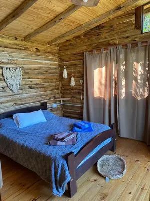 a bedroom with a bed in a log cabin at La retama in Alta Gracia