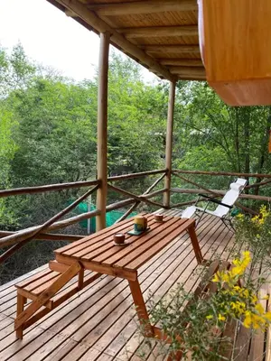 a wooden table and chairs on a wooden deck at La retama in Alta Gracia