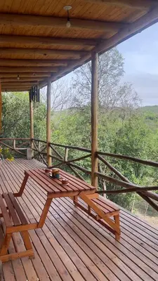 a wooden porch with a bench on a wooden deck at La retama in Alta Gracia
