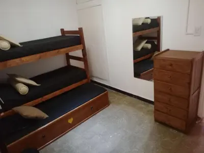 a room with bunk beds and a dresser and a mirror at Casa centrica in Villa Carlos Paz