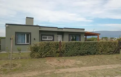a house with a hedge in front of it at La Puntana 