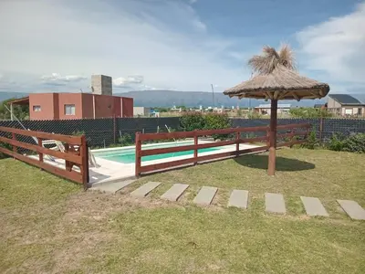 a pool with an umbrella and a fence at La Puntana 