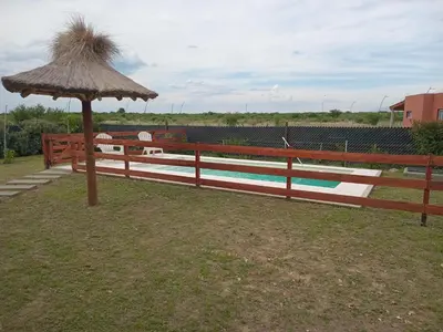 a wooden fence with an umbrella next to a pool at La Puntana 
