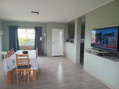 a living room with a dining table and a tv at La Puntana 