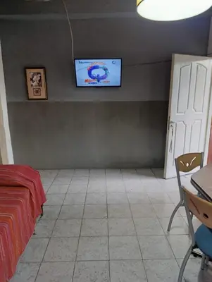 a bedroom with a bed and a tv on the wall at Alojamiento Nory's in Villa Carlos Paz