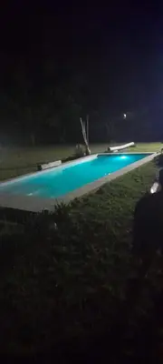 a swimming pool at night with a blue at Cabaña Eluney in Villa Ciudad Parque