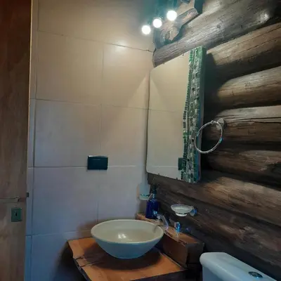 a bathroom with a bowl sink and a mirror at Cabaña Eluney in Villa Ciudad Parque
