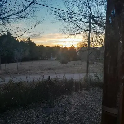 a view of a field with a sunset in the background at Cabaña Eluney in Villa Ciudad Parque
