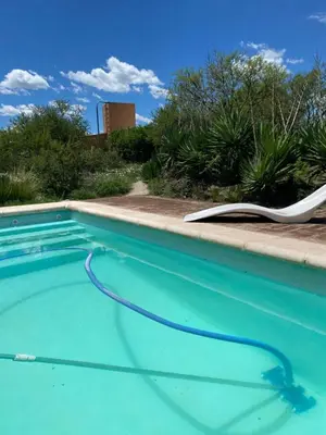 a swimming pool with a lawn chair and a hose at Las estrellas in Las Tapias