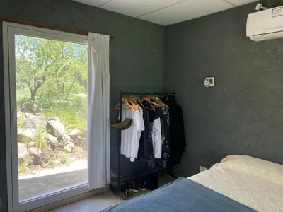 a bedroom with a window and a closet with clothes at Las estrellas in Las Tapias