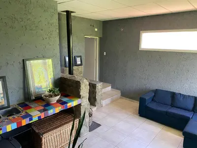 a waiting room with a blue chair and a table at Las estrellas in Las Tapias