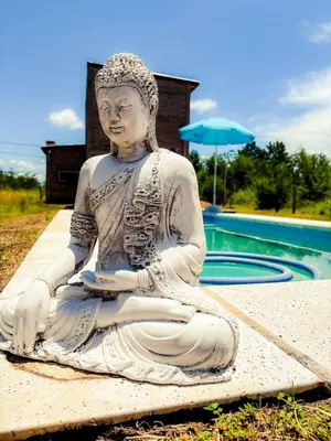 a statue of a woman sitting next to a pool at Cabañas El Nirvana Villa Quillinzo in Villa Quillinzo