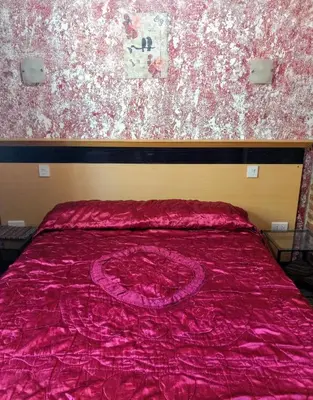 a bed with a red blanket on top of it at Rincón Soñado in Las Rabonas