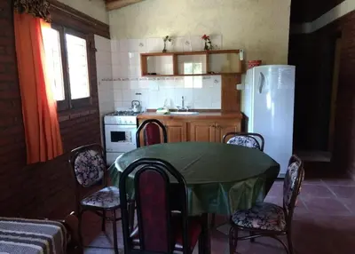 a kitchen with a table and a white refrigerator at Rincón Soñado in Las Rabonas