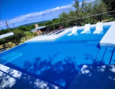 a large blue swimming pool with a view of the ocean at Rincón Soñado in Las Rabonas