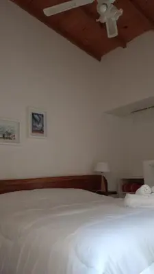 a bedroom with a white bed and a ceiling at Posada La Rosita - Casa in Santa Rosa de Calamuchita