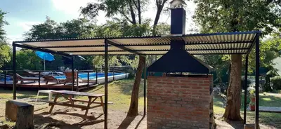 a pavilion with a table and a bench in a park at Posada La Rosita - Casa in Santa Rosa de Calamuchita