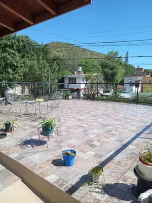 a patio with a table and chairs and plants at Casa en Villa Carlos Paz in Villa Carlos Paz