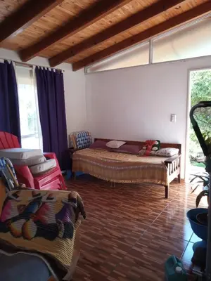 a living room with a bed and a couch at Casa en Villa Carlos Paz in Villa Carlos Paz