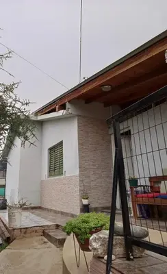 a white house with a window and a porch at Casa en Villa Carlos Paz in Villa Carlos Paz