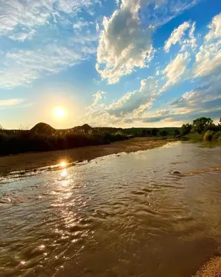 a river with the sun reflecting in the water at Casa Sol y Rio in Mina Clavero