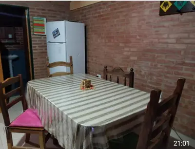 a kitchen with a table and a refrigerator at Casa Sol y Rio in Mina Clavero