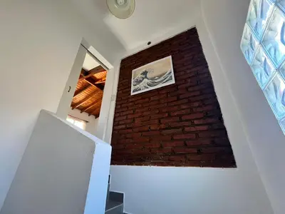 a staircase with a brick wall and a window at El Cuyanito Merlo in Merlo