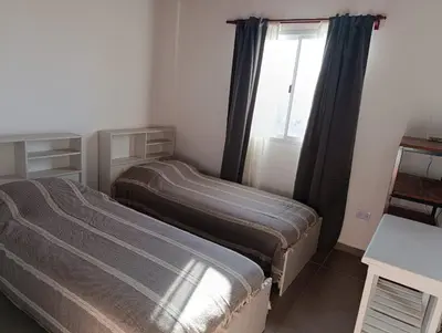 two beds in a room with a window at El Cuyanito Merlo in Merlo