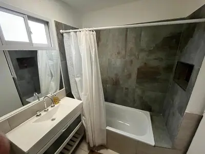 a bathroom with a tub and a sink and a shower at El Cuyanito Merlo in Merlo