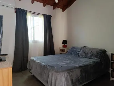 a bedroom with a bed and a window at El Cuyanito Merlo in Merlo