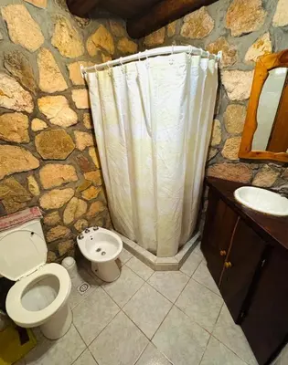 a stone bathroom with a toilet and a sink at Guathemoc cabañas in Panaholma