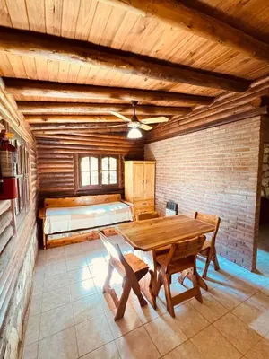 a room with a wooden table and a bed at Guathemoc cabañas in Panaholma