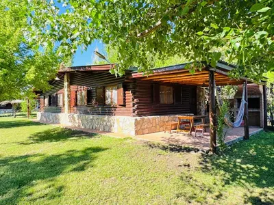 a log cabin with a table and chairs in front of it at Guathemoc cabañas in Panaholma