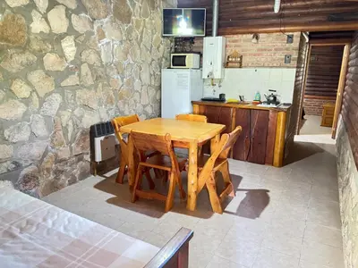 a kitchen with a wooden table with chairs and a refrigerator at Guathemoc cabañas in Panaholma