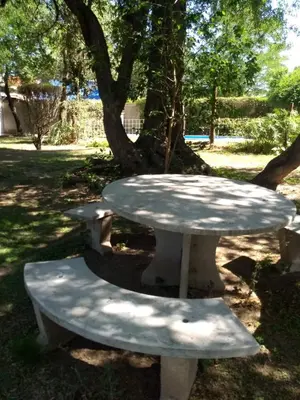 a picnic table in a park next to a tree at Al Sol de Traslasierra in Mina Clavero