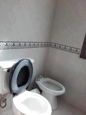 a bathroom with a white toilet and a sink at Al Sol de Traslasierra in Mina Clavero