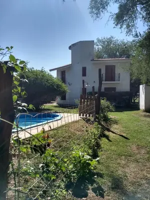 a house with a pool and a fence at Al Sol de Traslasierra in Mina Clavero