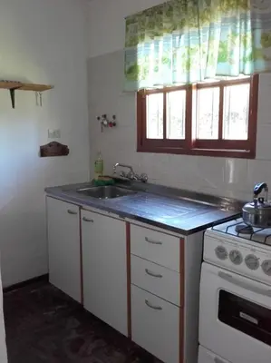 a kitchen with a sink and a stove at Al Sol de Traslasierra in Mina Clavero