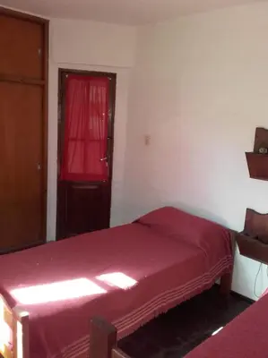 a bedroom with a red bed and a red window at Al Sol de Traslasierra in Mina Clavero