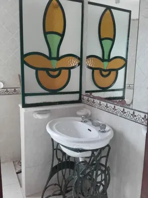 a bathroom with a sink and two pictures on the wall at Al Sol de Traslasierra in Mina Clavero
