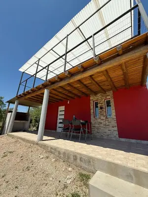 awning over a patio of a house with a table at Cabañas Campo y Río in San Lorenzo