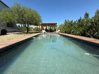 a swimming pool with a hose in the water at Cabañas Campo y Río in San Lorenzo